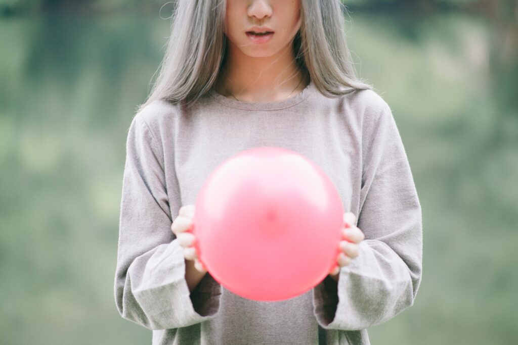 girl with silver hair and pink balloon