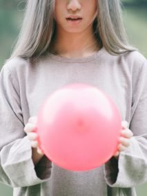 girl with silver hair and pink balloon