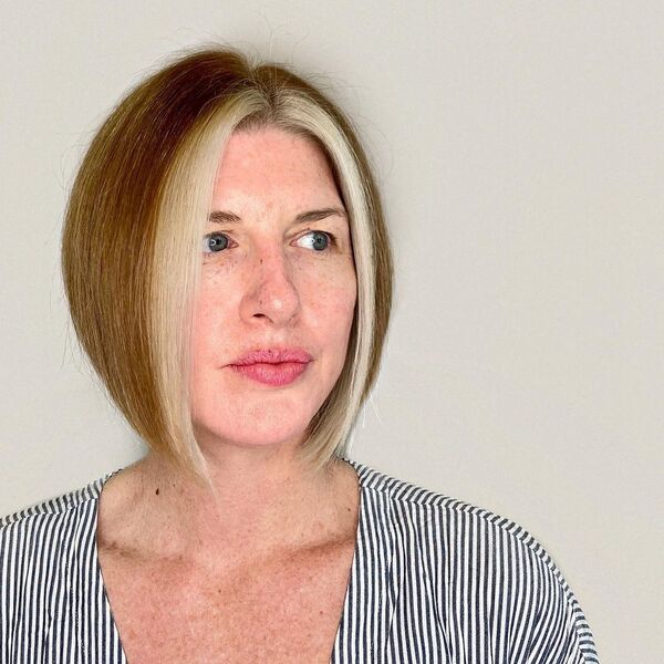 Bob Cut with Front Platinum Streak - a woman wearing a printed black and white v-neck shirt