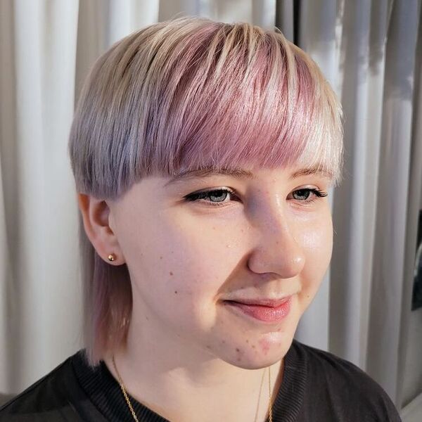 Pastel Colored Short Wolf Haircut - a woman wearing a black shirt and an earrings and necklace