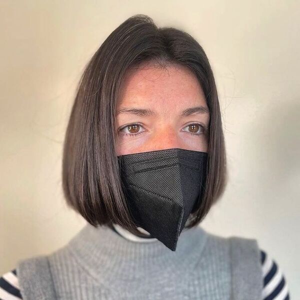 Simple Smooth Bob - a woman wearing a facemask and has a brown eyes