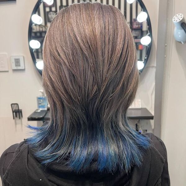 Ash Blonde Wolf Cut with Blue Tint Underlayer - a woman wearing a black hooded jacket.