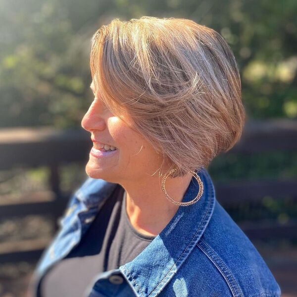 Blonde Short Bob - a woman wearing a denim jacket and a round earrings