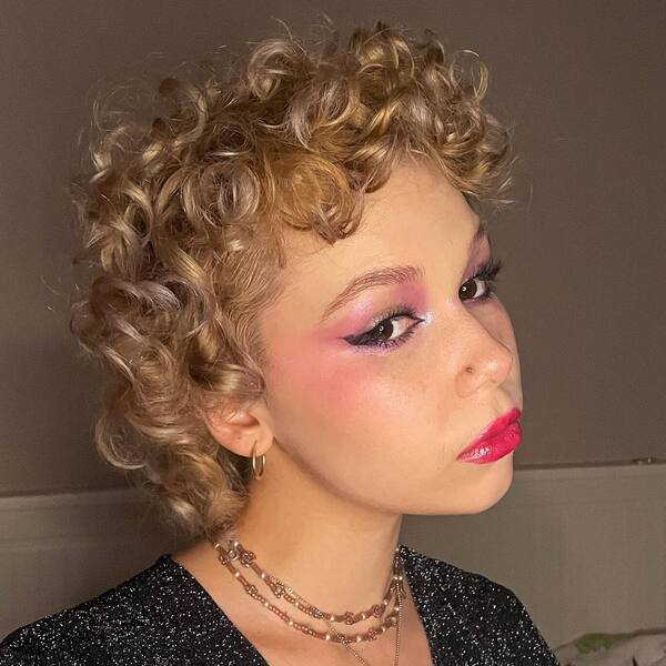 Blunt Curl Mullet - a woman wearing full glam make-up with shiny dress.