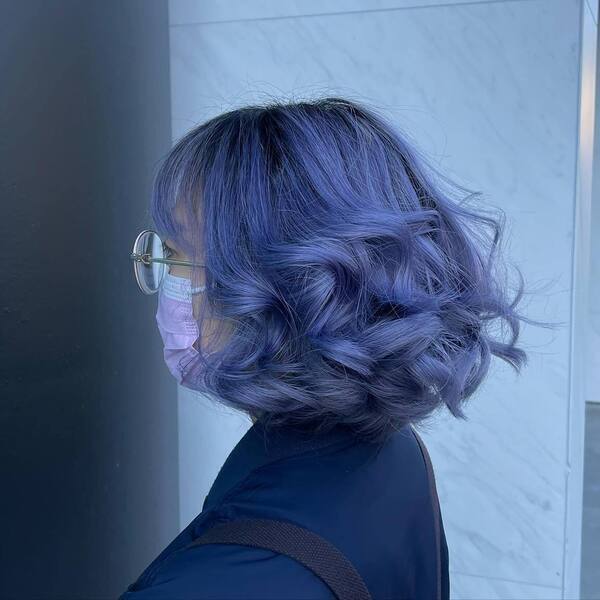 Curled Lavender Bob - a woman wearing dark blue shirt with bag pack.