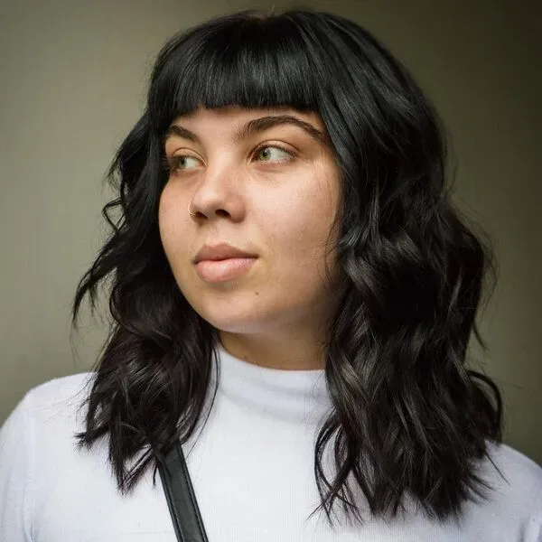 Long Bob with Bangs - a woman wearing a plain white turtle neck long sleeves.