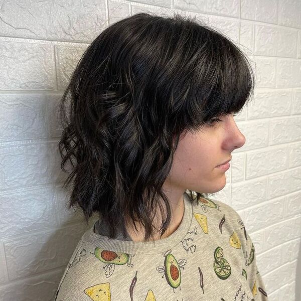 Shag Hairstyle with Volume Bangs - a woman wearing a printed shirt.