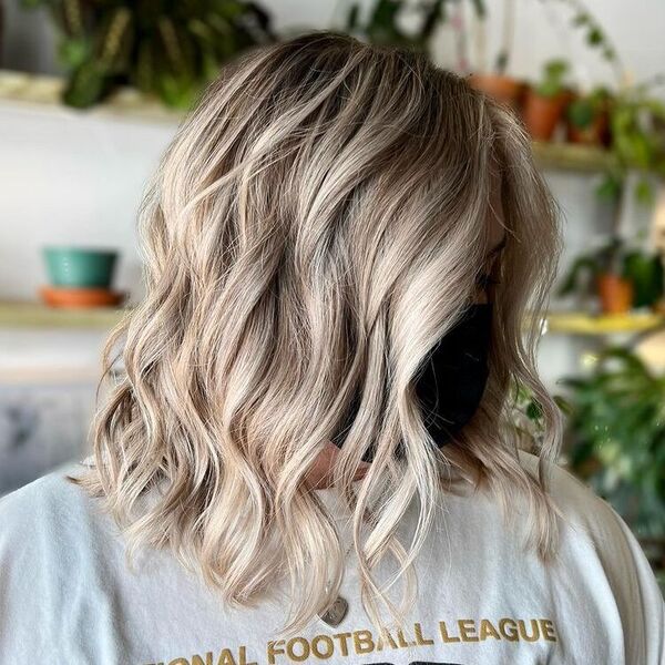Sophisticated Lob with Platinum Balayage - a woman wearing a football shirt and a mask