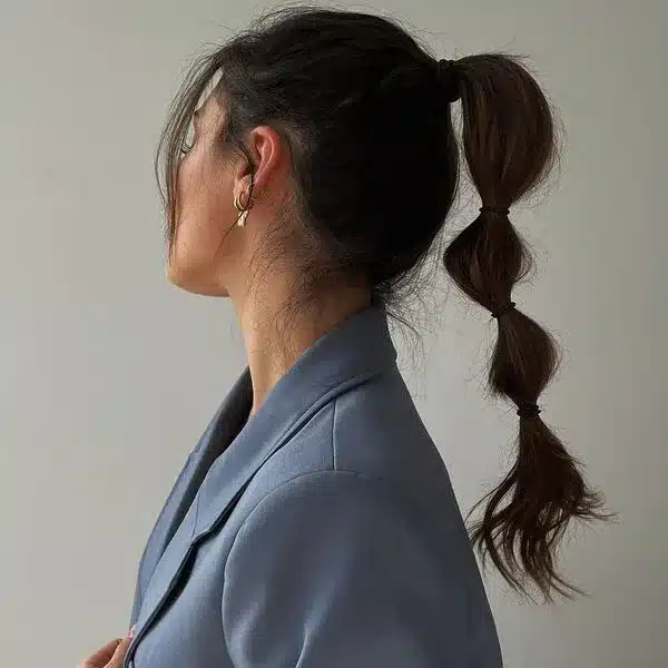 Swoop Ponytails - a woman wearing teal blue coat.