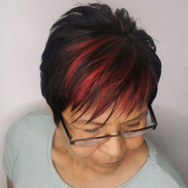 Contrasting Choppy Pixie Haircut with Red Highlights - A woman wearing eyeglasses