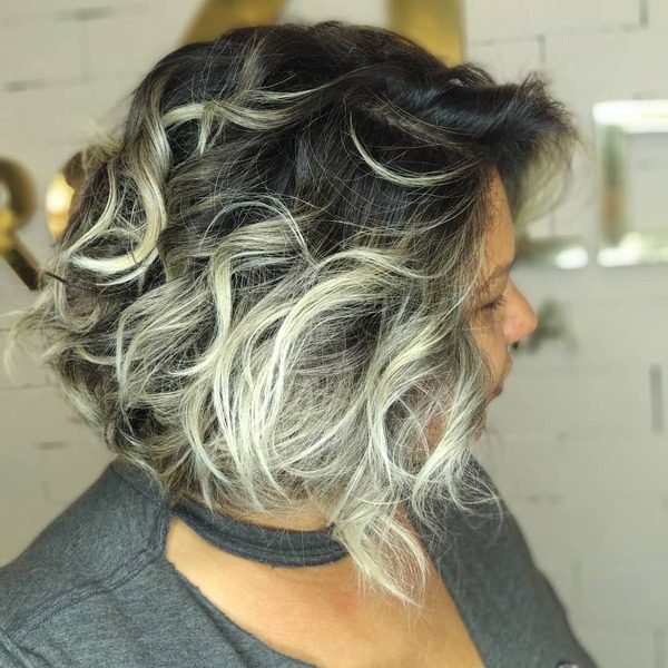 Curly Platinum Highlights Bob - a woman wearing gray blouse.