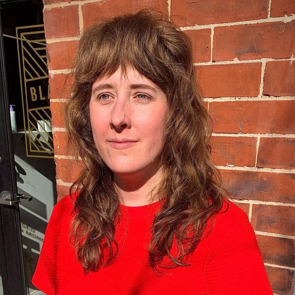 Dried Shag Mullet with Curtain Bangs - A woman wearing a red top