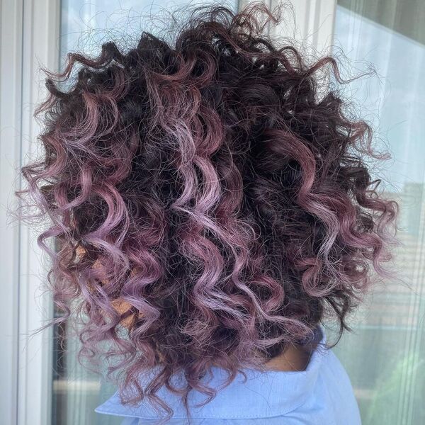 Messy Spiral Curls with Purple Streaks - a woman wearing sky blue polo