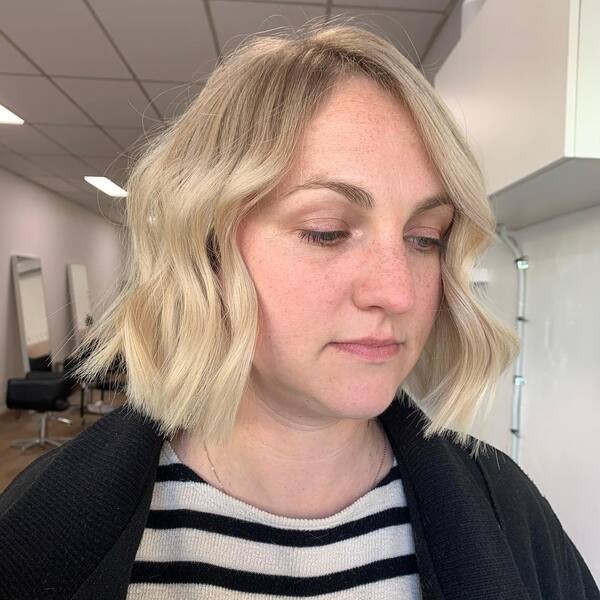 Shag Blonde Bob - a woman wearing stripe top with black cardigan.