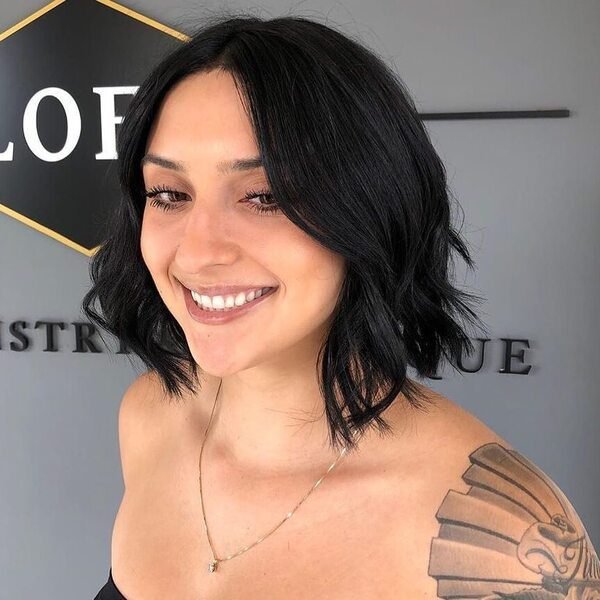 Sophisticated Wavy Short Bob - a woman wearing gold necklace in black tube.