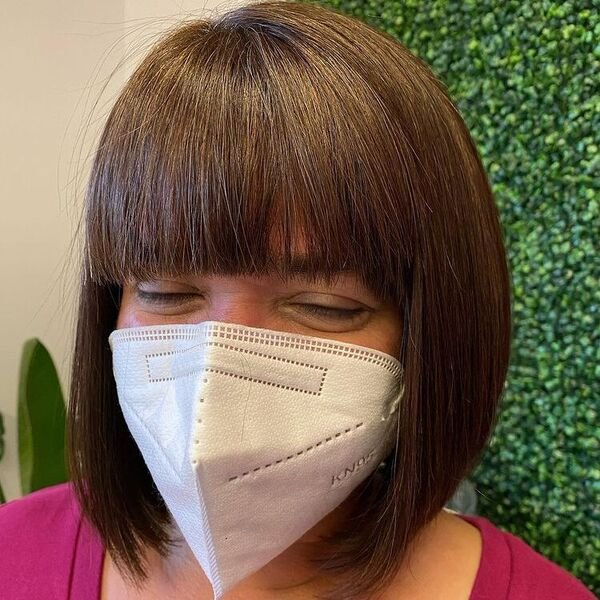 Stunning Straight Bob with Blunt Bangs - a woman wearing mask and pink shirt.