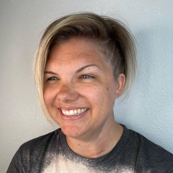 Swept Side Undercut Blonde - a woman wearing black printed shirt.