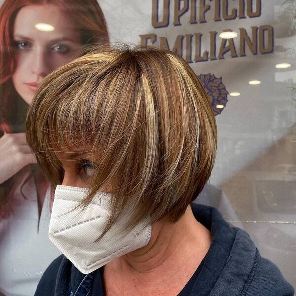 Two Toned Short Bob with Bangs - a woman is wearing white mask in dark blue hood jacket.
