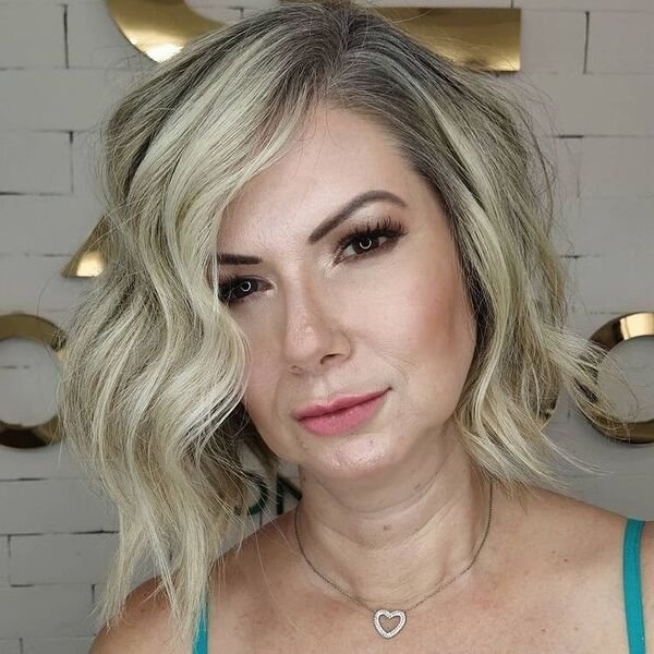 Wavy Blonde Short Bob - a woman wearing sage green tank top.
