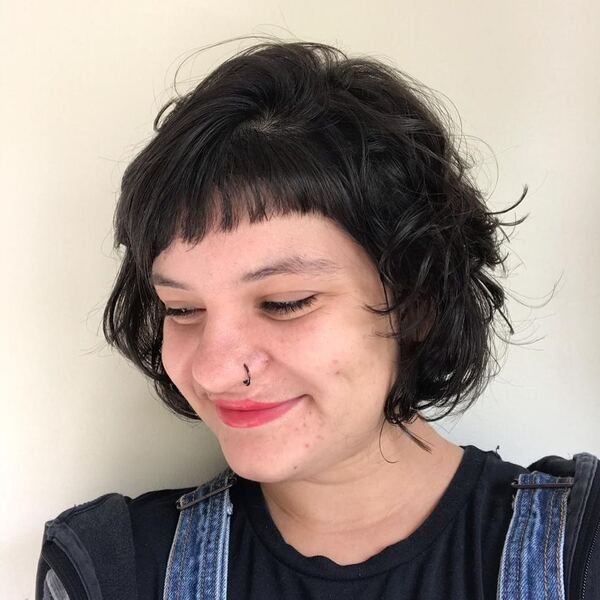 Wispy Choppy Short Bob - a woman wearing black shirt with denim jumper.