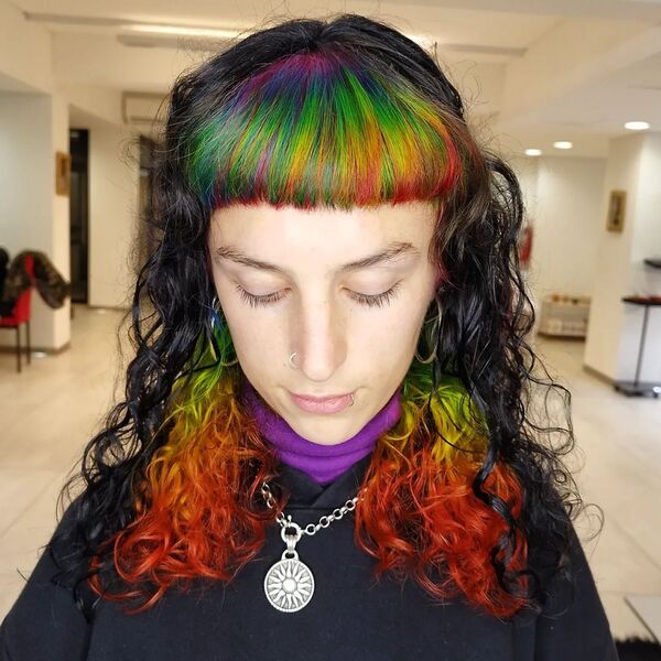 Black and Rainbow Curly Hair - a woman wearing a black hooded jacket