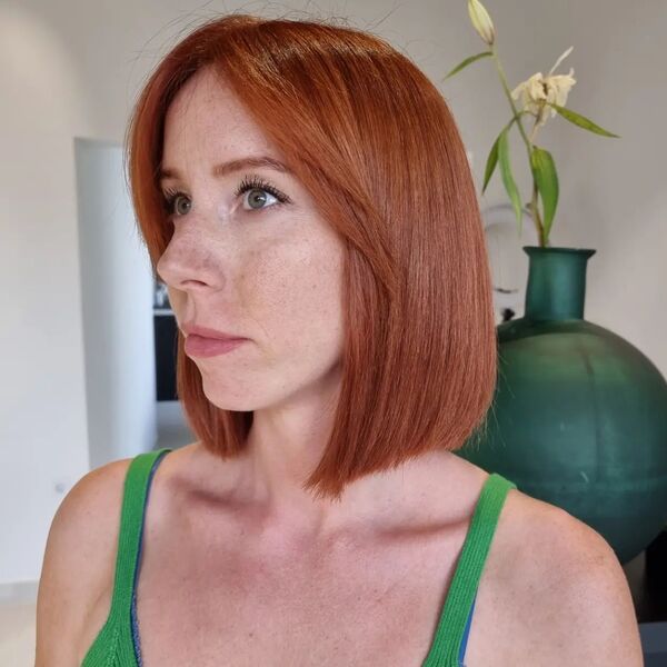 Blunt Bob with Side Bangs - a woman wearing a green spaghetti strap top