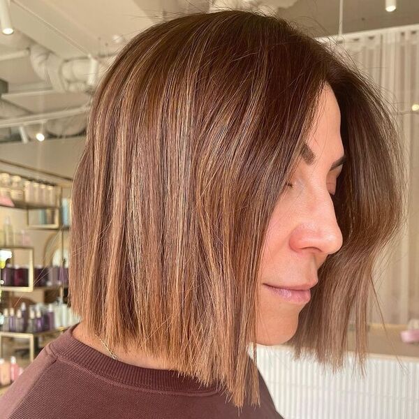 Brown with Highlights Blunt Bob - a woman wearing brown top