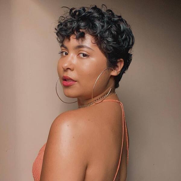 Curly Pixie Cut - a woman wearing a backless dress