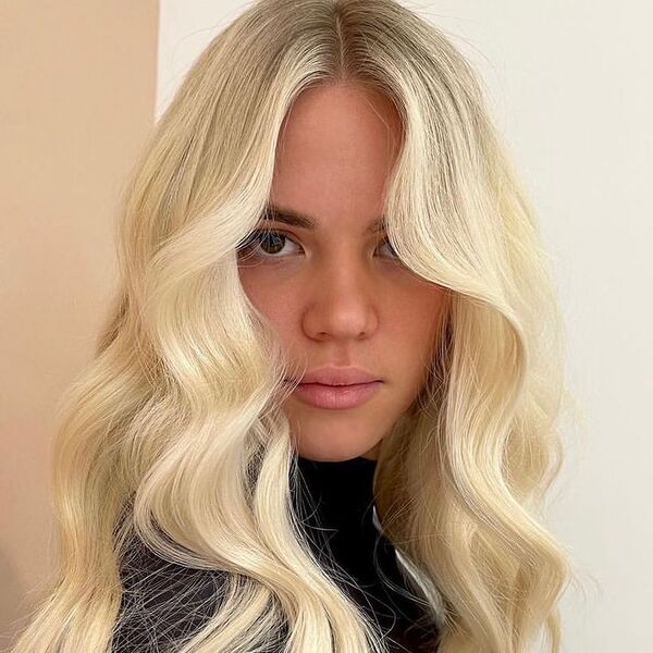 Full Cream Blonde Wavy Hairstyle - a woman wearing turtle neck