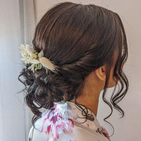 Messy Low Bun with White Flower - a woman wearing a floral blouse