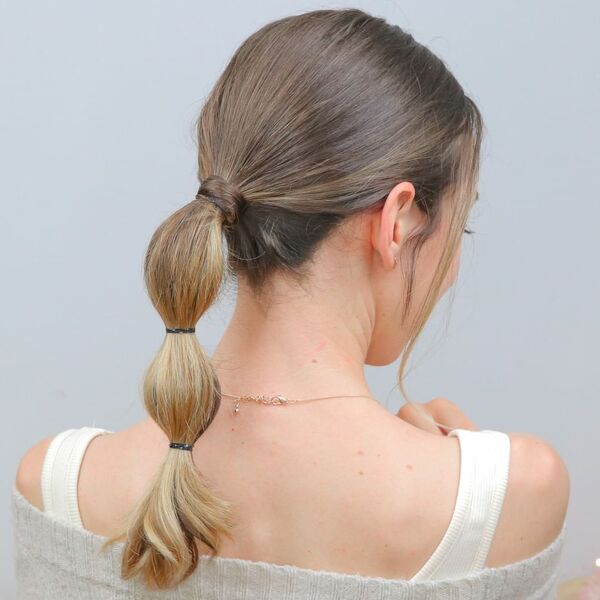 Mid-Length Bubble Ponytail - a woman wearing a necklace