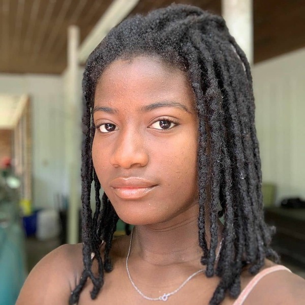 Mid-Length Dreadlocks Hairstyle - a woman wearing a necklace