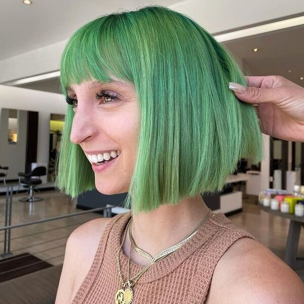 Mint Green French Bob Cut - a woman with necklace wearing a brown sleeveless top