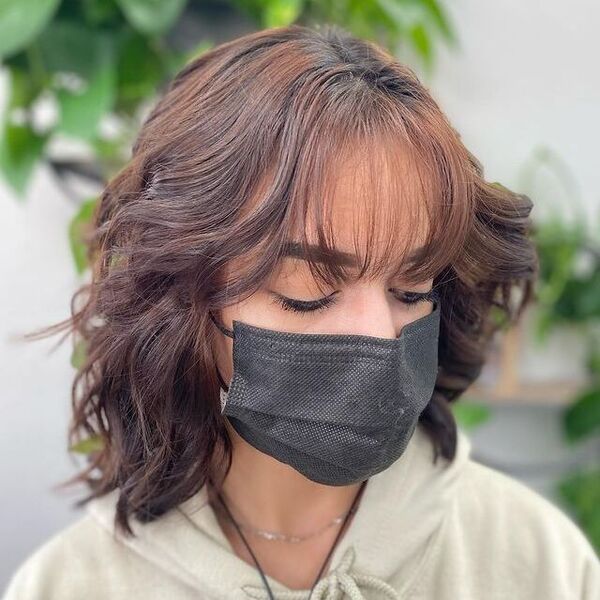 Bangs for Shaggy Cut - a woman wearing a black facemask