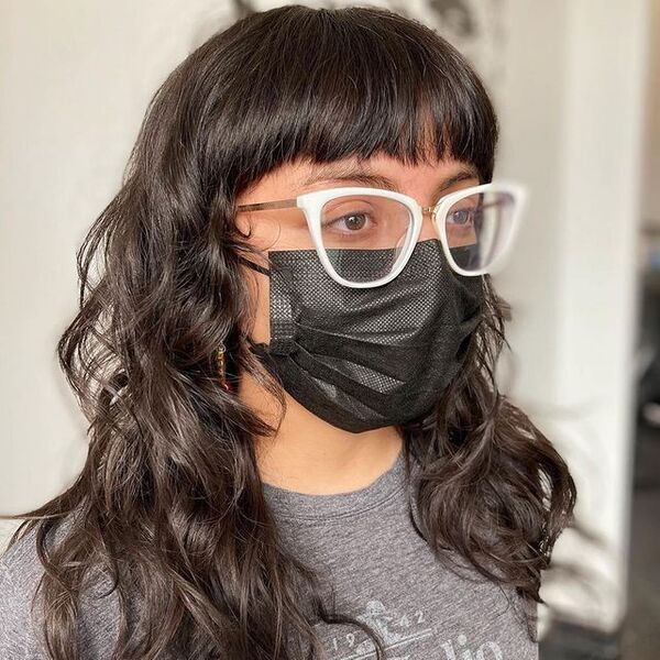 a woman wearing a eyeglasses and black facemask