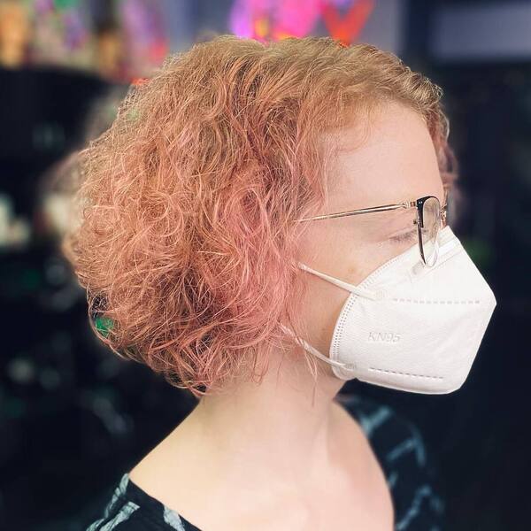 Curly Rose Gold - a woman wearing a eyeglasses and white KN95 facemask