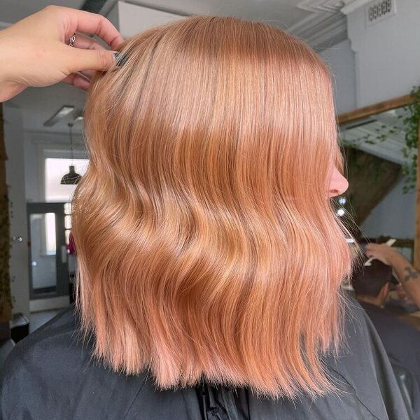 Glossy Rose Gold Hair - a woman wearing a black cape