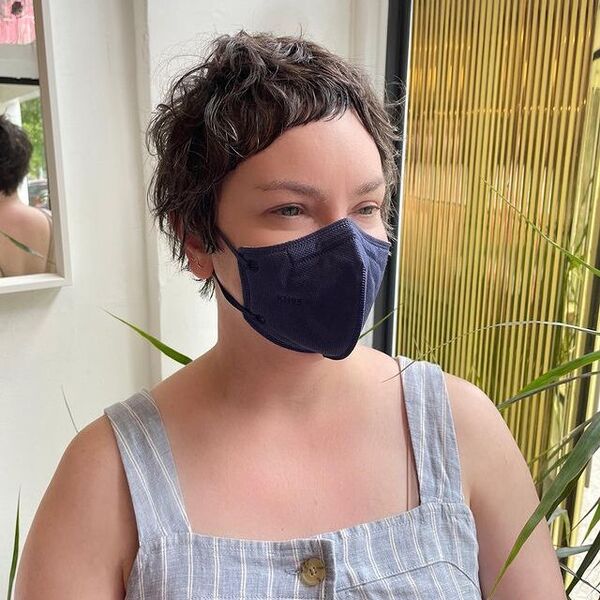 short bangs - a woman wearing a dark blue KN95 facemask