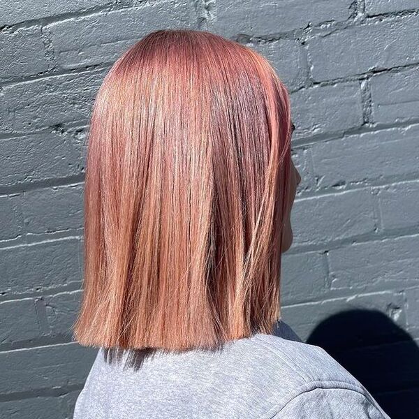 Pearlised Peachy Pink Hairstyle - a woman wearing a gray shirt