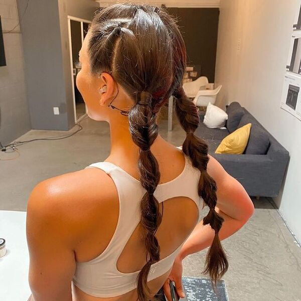 Twisted Pigtails Braids - a woman wearing a white sports bra