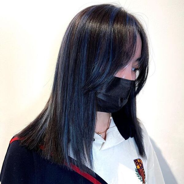 a woman wearing a black facemask has a subtle  blue hair