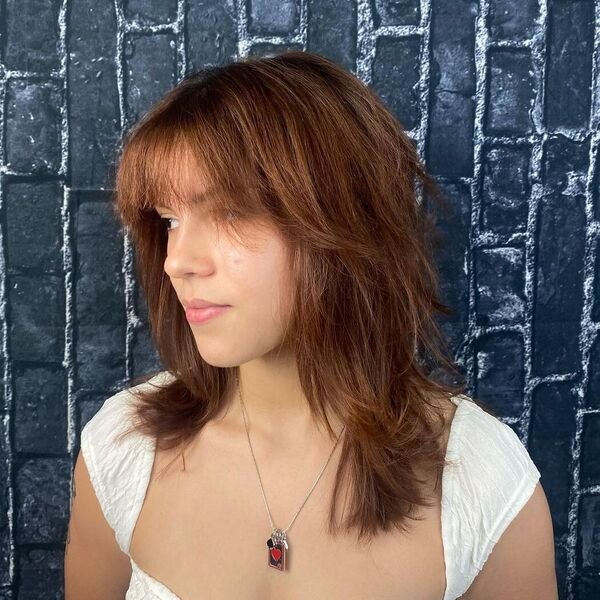A woman wearing a necklace and white top
