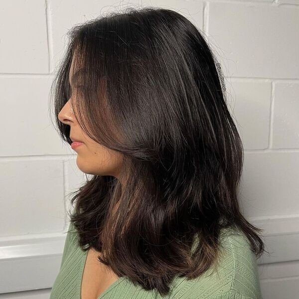 A woman wearing green top with her wash and go hairstyles