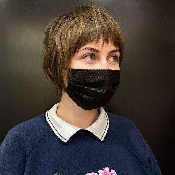 a woman with black facemask wearing a blue printed longsleeve