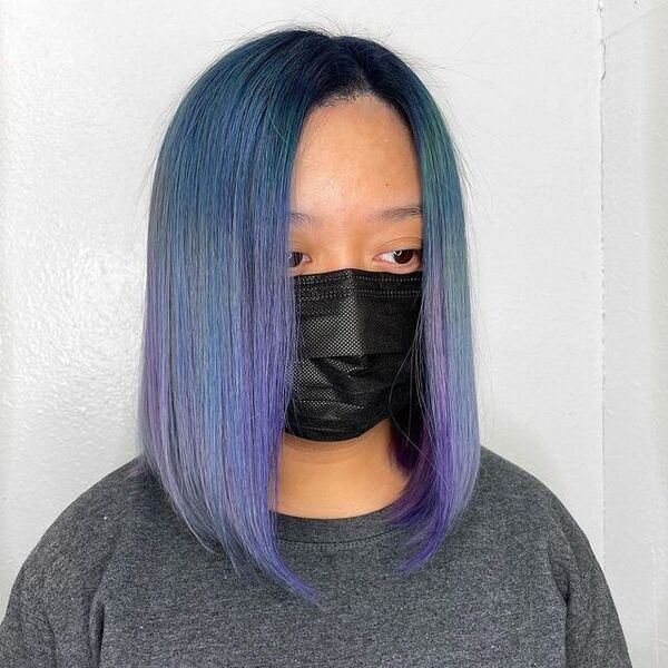 a woman with black facemask wearing a gray shirt having her ocean magic hairstyle