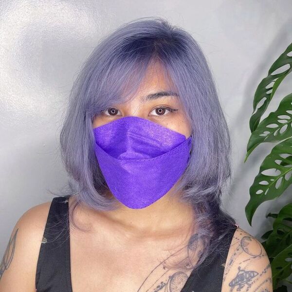 a woman with purple facemask wearing a black sleeveless shirt