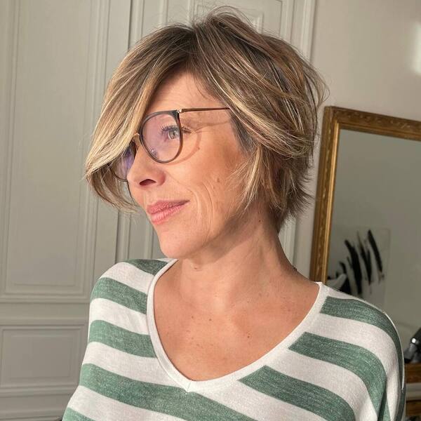 a woman with eyeglasses wearing a stripe blouse