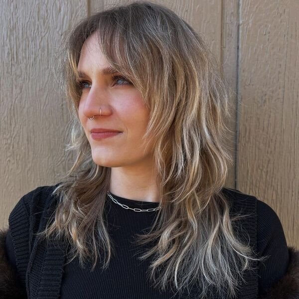 A woman wearing black outfit, necklace and piercings with her lovely shag layered wash and go hair