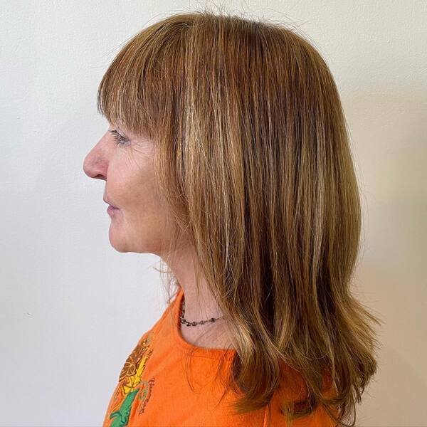 A woman wearing orange rounded shirt with her wash and go hairstyles